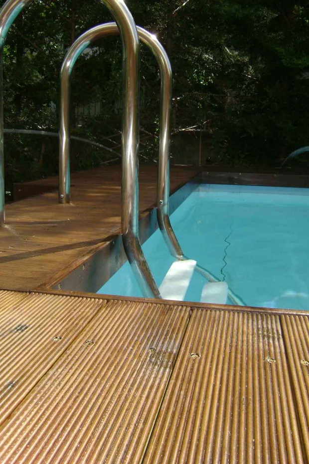Επένδυση λυόμενης πισίνας από εμποτισμένη ξυλεία πεύκης, τοποθετημένη βιδωτά πάνω σε ξύλινο εμποτισμένο σκελετό. Κατασκεύη σκάλας για την πρόσβαση σε αυτή.