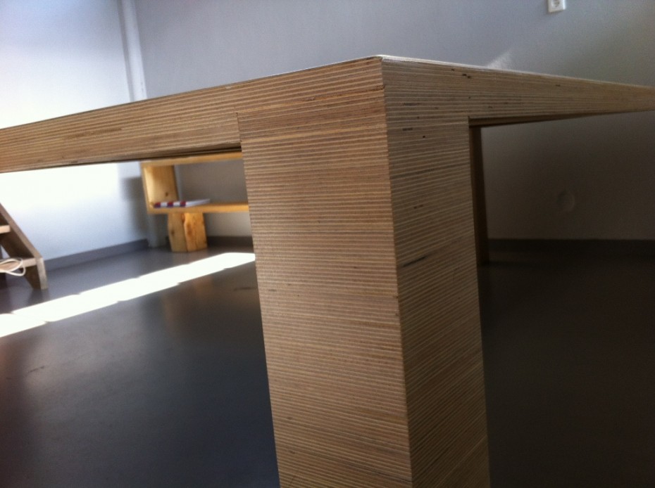 Ανοιχτόχρωμο τραπέζι από κόντρα πλακέ με λιτές, αυστηρές γραμμές.