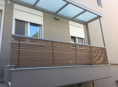 Διαμόρφωση εξωτερικού χώρου σε μπαλκόνι αποτελούμενη από στέγαστρο με κάλυψη από με γυαλί τρίπλεξ ματ και κάγκελα από μεταλλικούς γαλβανισμένους ορθοστάτες και επένδυση από εμποτισμένη ξυλεία πεύκης